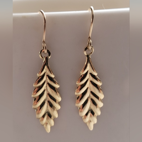 Gold dangle earrings featuring a naturalistic leaf motif. - Picture 1 of 8